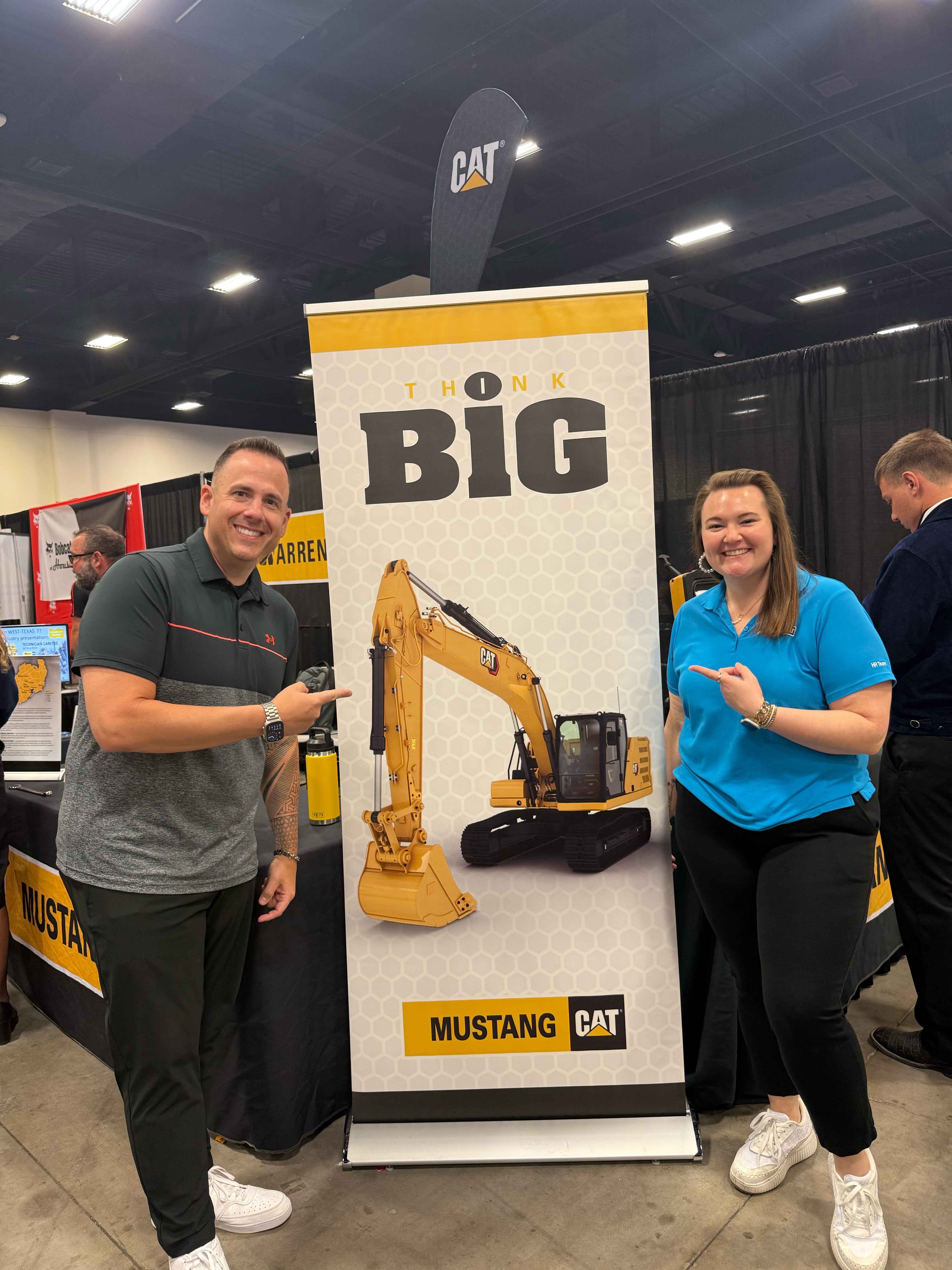 Sarah Bell with the Mustang CAT Think BIG banner